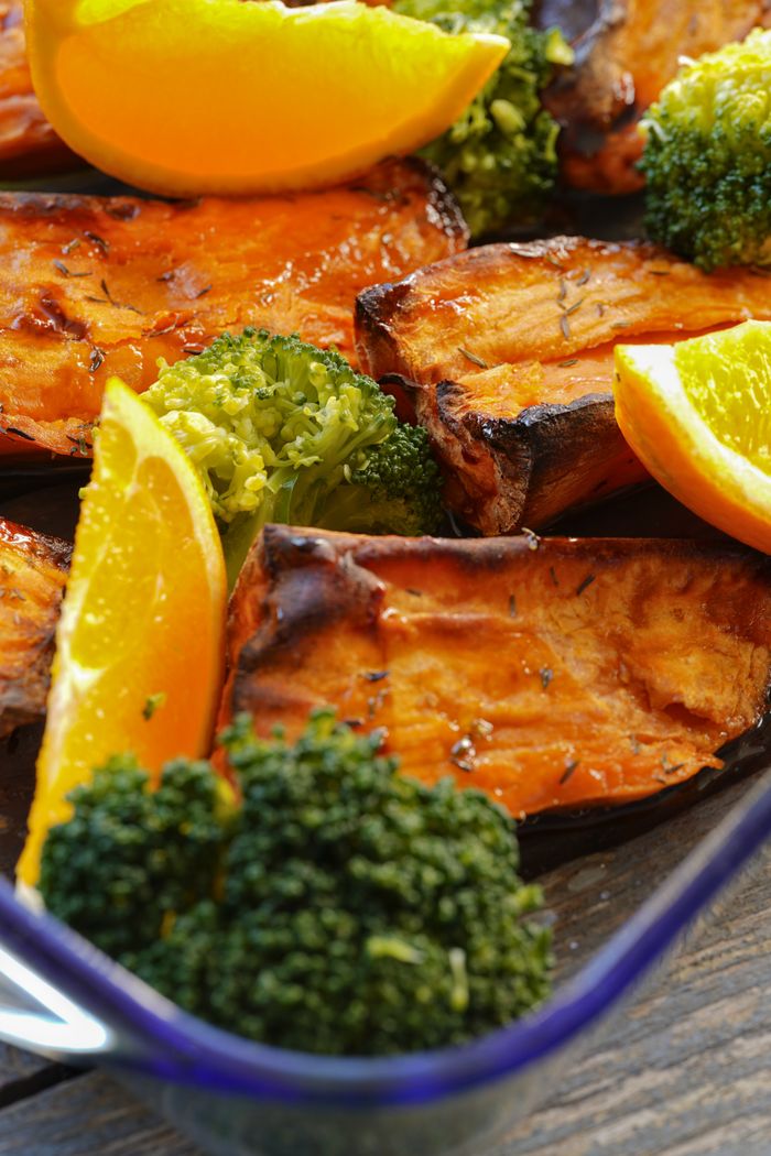 Delicious roasted sweet potatoes with broccoli and orange slices, a vibrant and healthy dish.